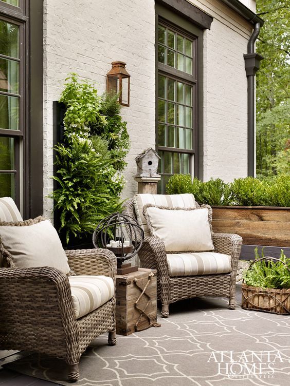 two wicker chairs sitting on top of a patio