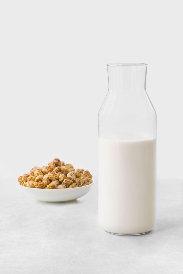 a bowl of cereal next to a bottle of milk