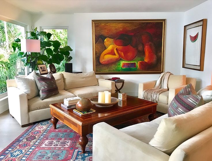 a living room filled with furniture and a painting on the wall