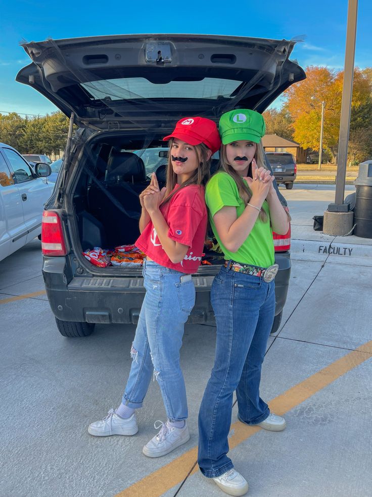 two people standing next to each other in front of a car with the trunk open