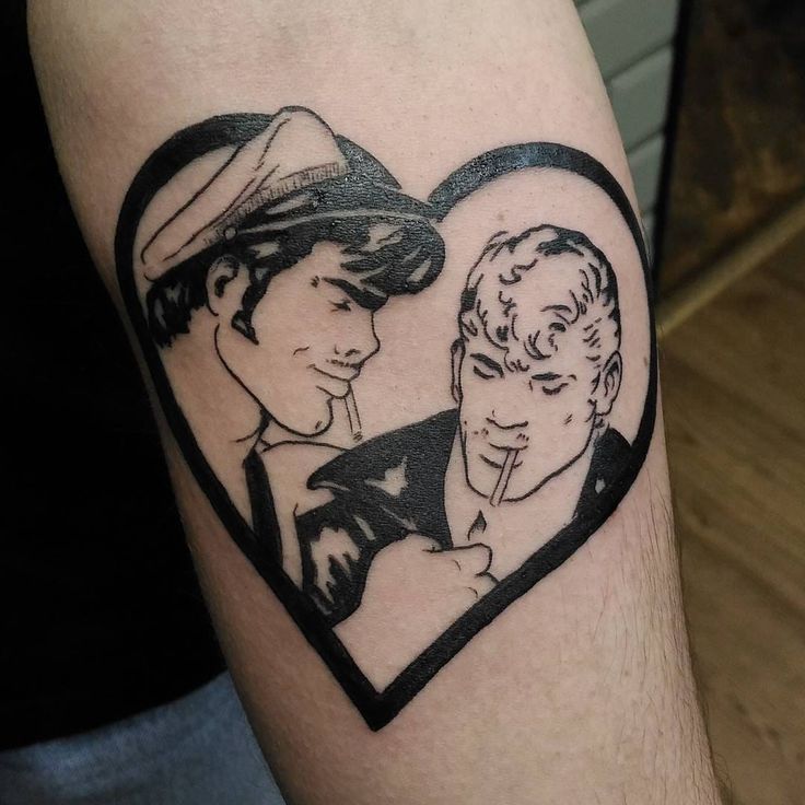 a couple in a heart tattoo on the arm