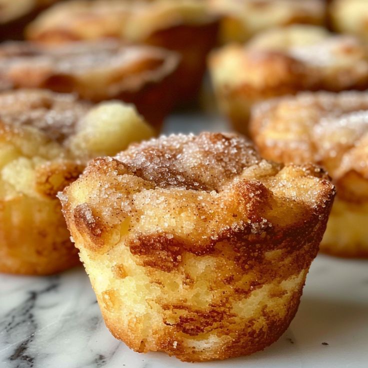 some sugary muffins are sitting on a marble counter top and ready to be eaten