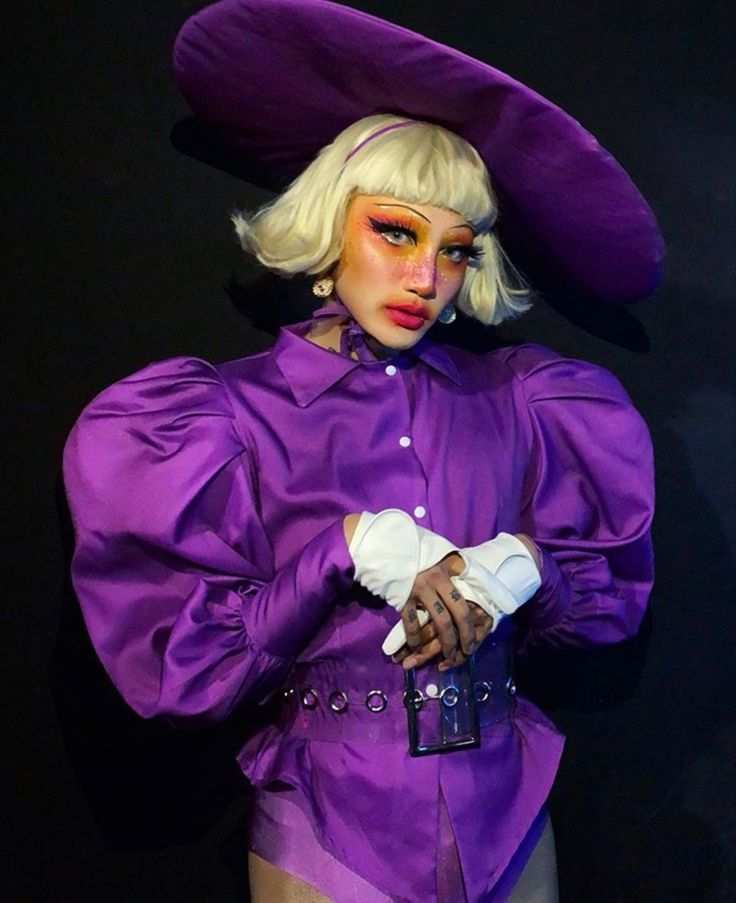 a woman in a purple outfit and hat