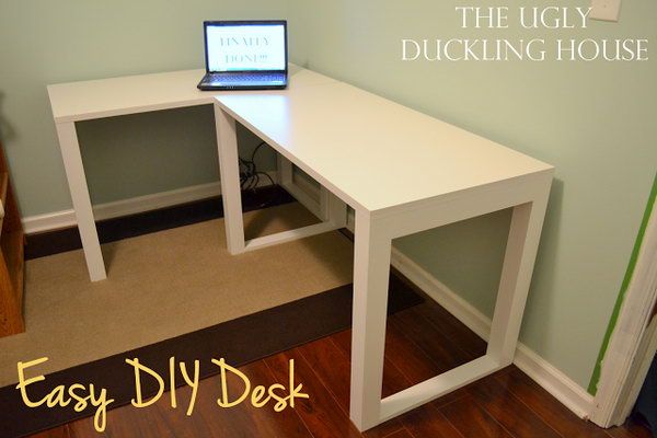 a white desk with a laptop on top of it in the corner of a room