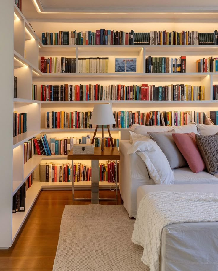 a bed sitting in front of a bookshelf filled with lots of book shelves