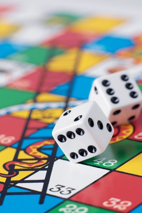 two white dices sitting on top of a colorful board game