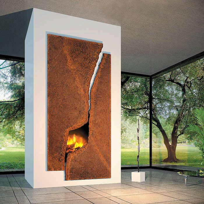 a fire place in the middle of a room with large windows and trees outside it