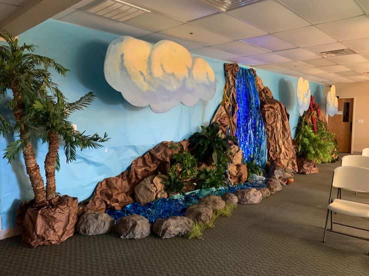 an office decorated with fake waterfall and palm trees