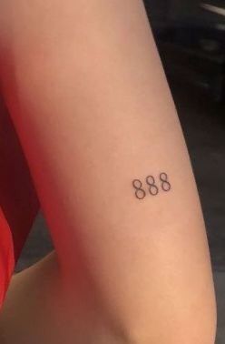 a woman with a small tattoo on her arm that reads'868'in cursive font