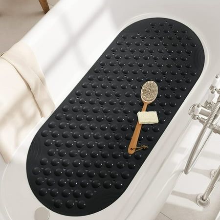 a bathtub with a wooden spoon and cheese on the mat in front of it