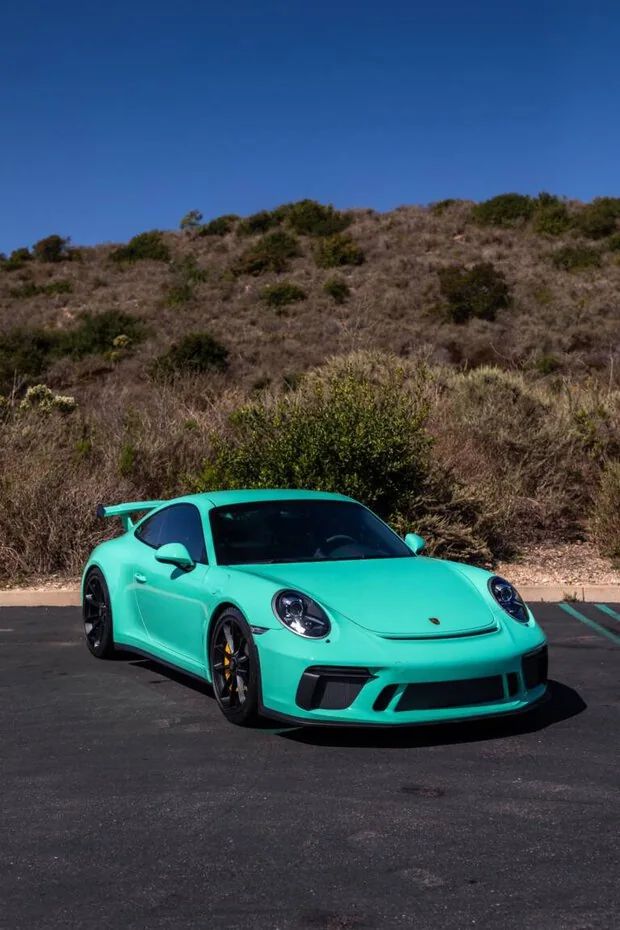 a blue porsche parked in a parking lot