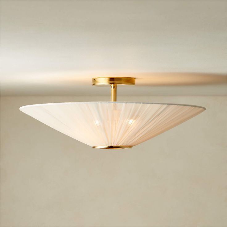 a ceiling light with a white shade on it's glass bowl and gold trim