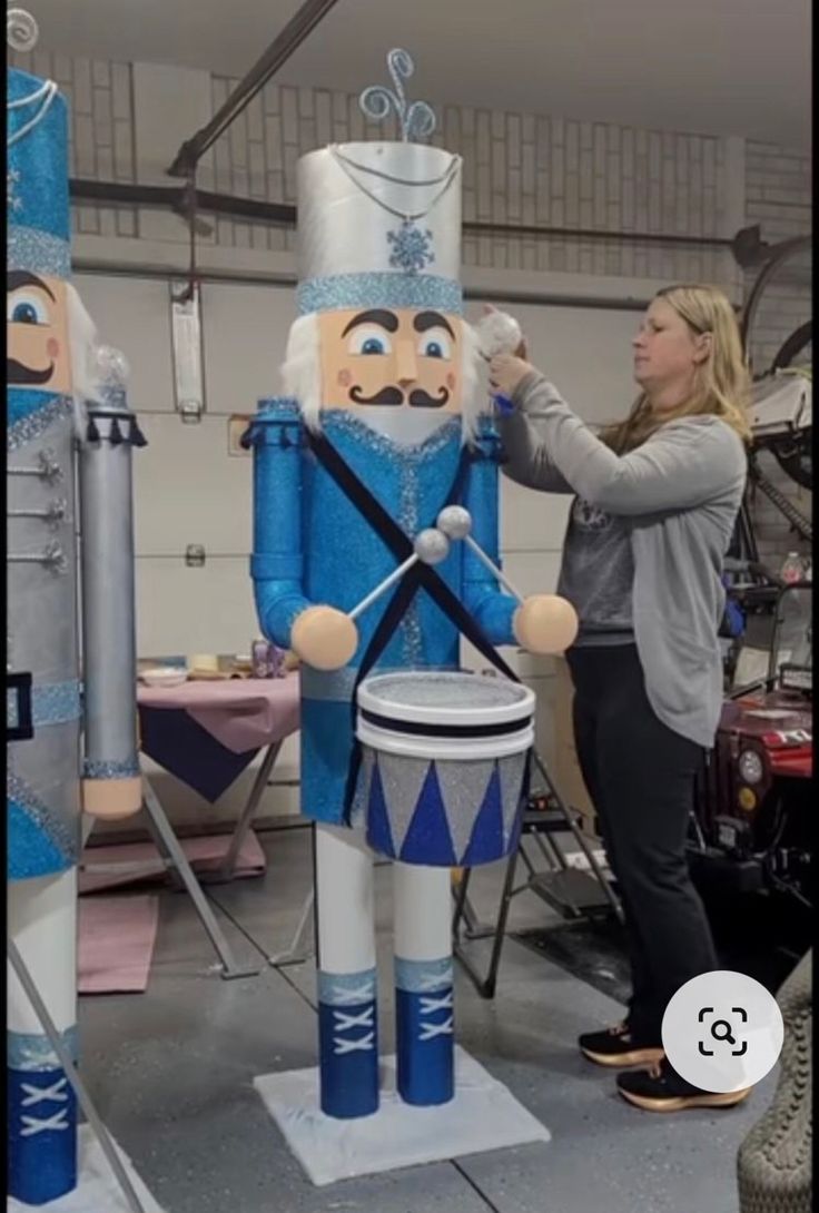 a woman standing next to a giant nutcracker