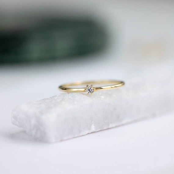 A dainty 14K gold solitaire ring with a tiny diamond 2mm. This stacking diamond ring can be an affordable engagement ring. Its minimalist style makes it perfect for women who love simple elegant jewelry. 100% handcrafted with love!D E T A I L S● Metal: 14K solid gold● Gemstones: Diamond● Diamond's weight: .035ct● Diamond's Cut: BrilliantR I N G ∙ S I Z I N GFor General Reference:● we use standard US Ring Sizing● an average women's ring finger is size 6-7● each ring is custom made upon order, in Dainty Single Diamond Ring For Anniversary, Dainty Single Diamond Anniversary Ring, Simple Yellow Gold Diamond Ring, Simple 14k Gold Birthstone Ring For Anniversary, Minimalist Round Cut Diamond Birthstone Ring, Simple Yellow Gold Stackable Rings, Minimalist Diamond White Birthstone Ring, Simple Round Cut Diamond Ring, Minimalist Solitaire Birthstone Ring For Anniversary