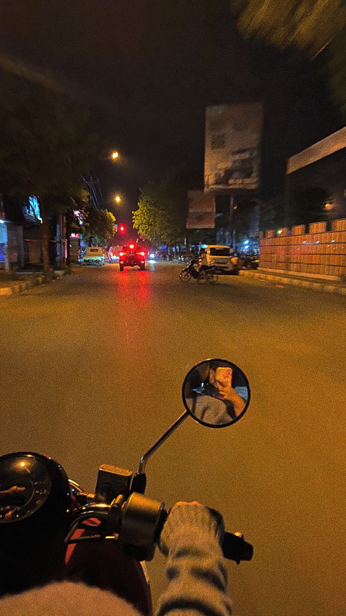 a person riding a motorcycle down a street at night