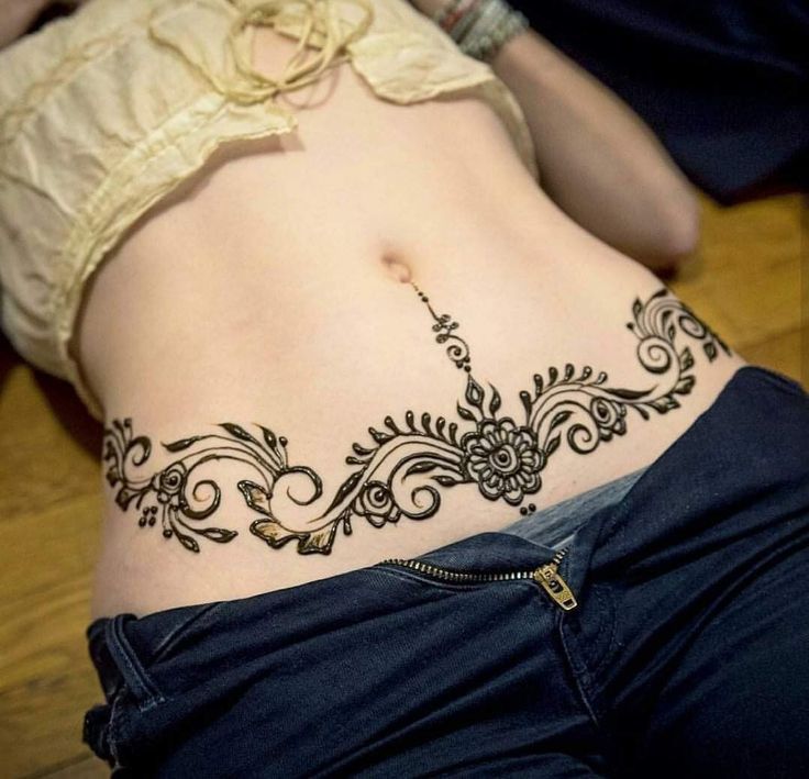 a woman's stomach with a tattoo design on her belly and the bottom part of her lower body