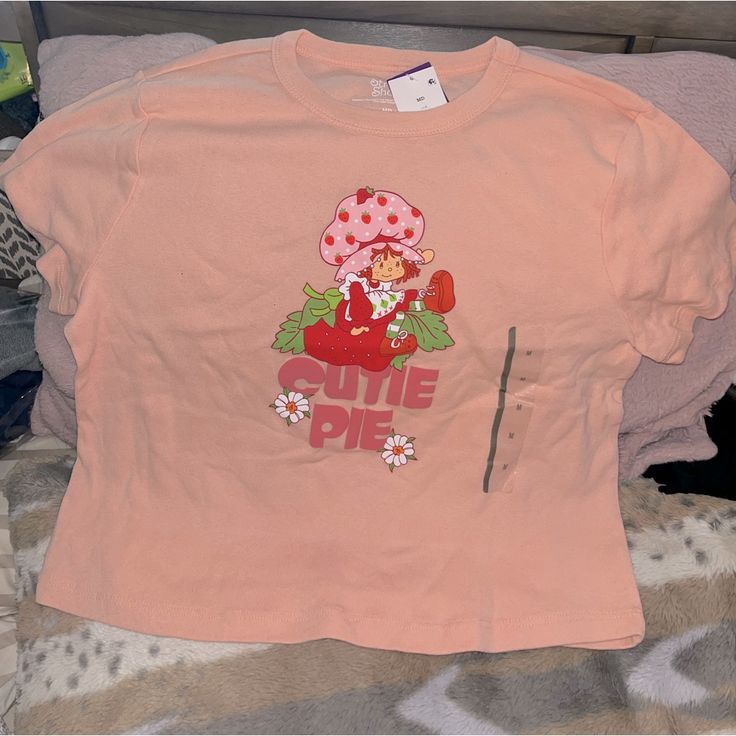 Brand New With Tag Strawberry Shortcake T-Shirt Size Medium In Junior’s Cute Crew Neck Tops For Spring, Sweet Style T-shirt With Funny Print For Spring, Sweet Tops With Funny Print And Crew Neck, Cute Short Sleeve Tops With Funny Print, Sweet Crew Neck Top For Spring, Sweet Short Sleeve Cotton Shirt, Sweet Short Sleeve Tops With Funny Print, Pink Short Sleeve Sweet Top, Cute Spring Streetwear Tops