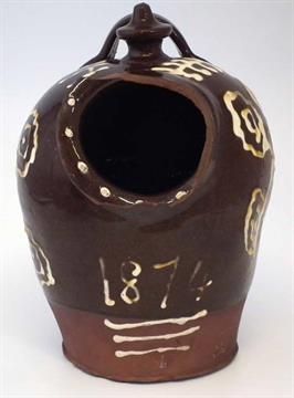 a brown and white vase sitting on top of a table with numbers painted on it