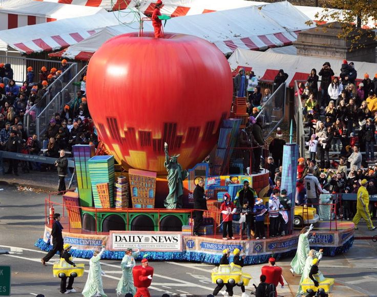 a parade float in the middle of a street with lots of people walking around it