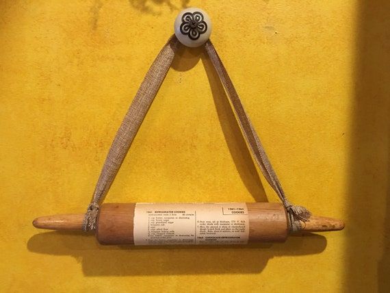 a rolled up piece of paper hanging on a wall with a wooden stick attached to it