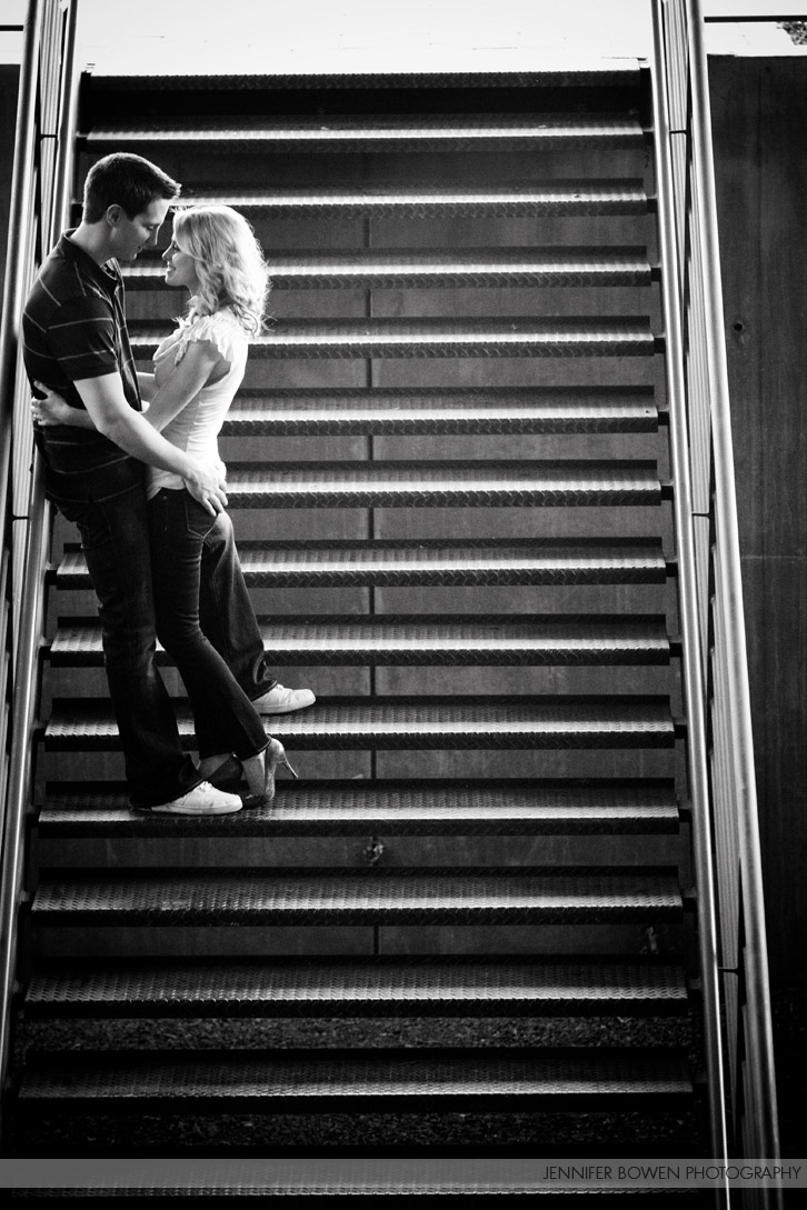 a man and woman standing on top of an escalator