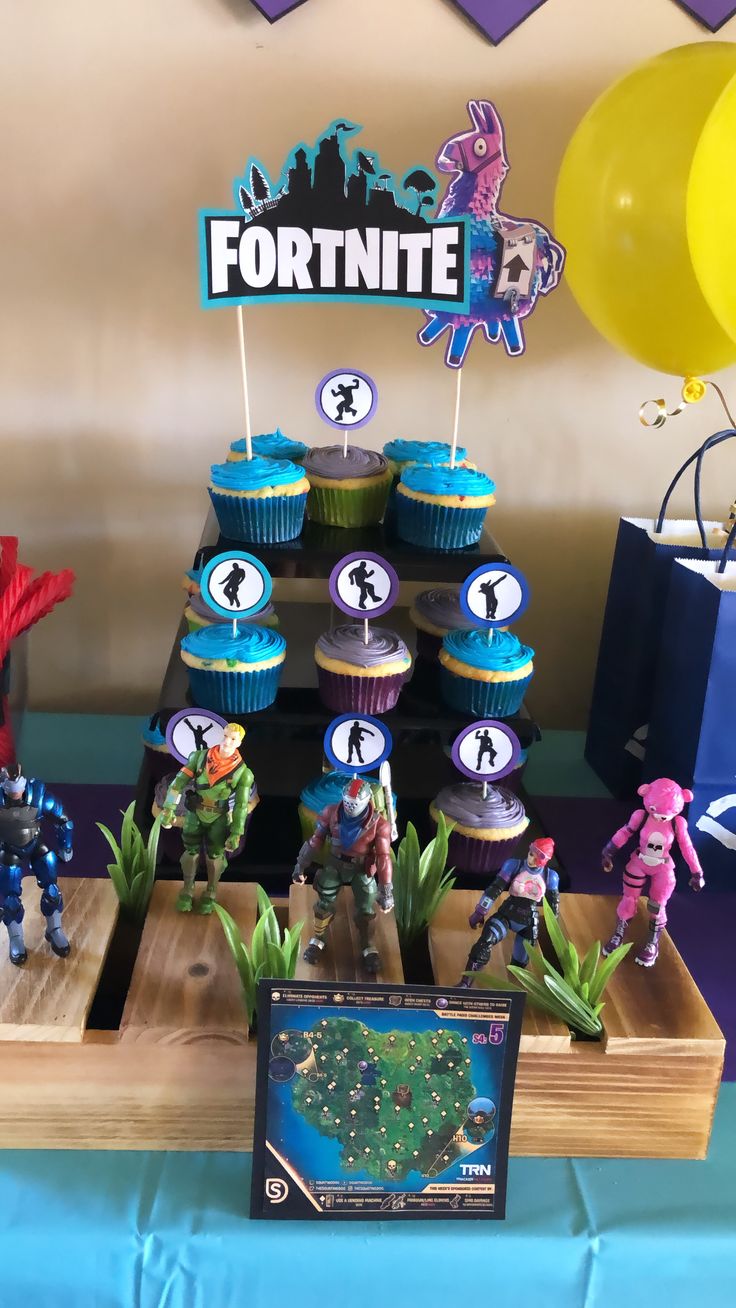 a table topped with cupcakes and toy figurines