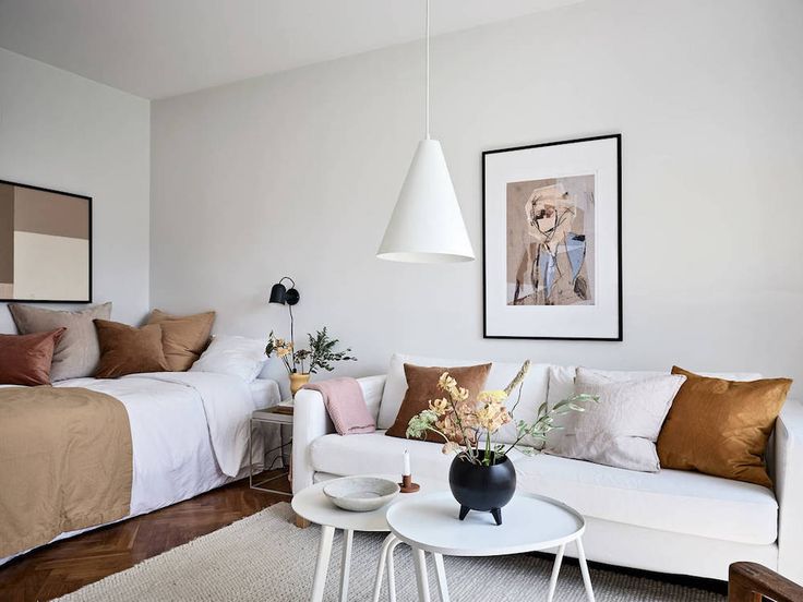 a living room filled with white furniture and lots of pillows on top of it's covers