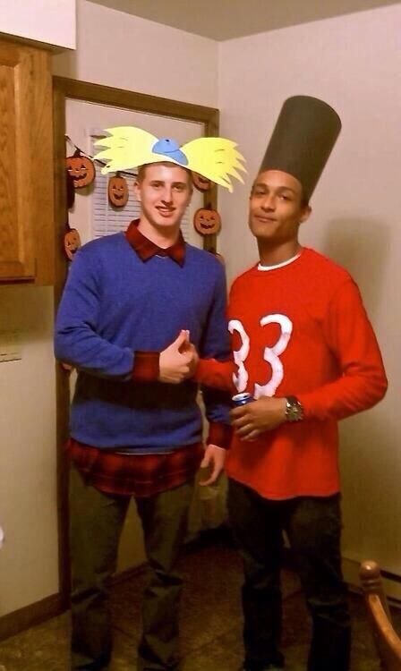 two young men dressed in costumes standing next to each other with hats on their heads