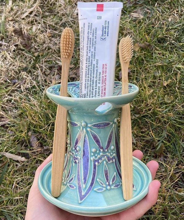 two toothbrushes in a cup on the grass