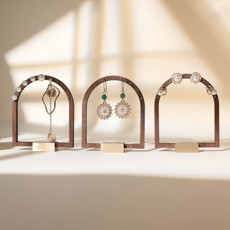 three wooden jewelry stands with earrings on them