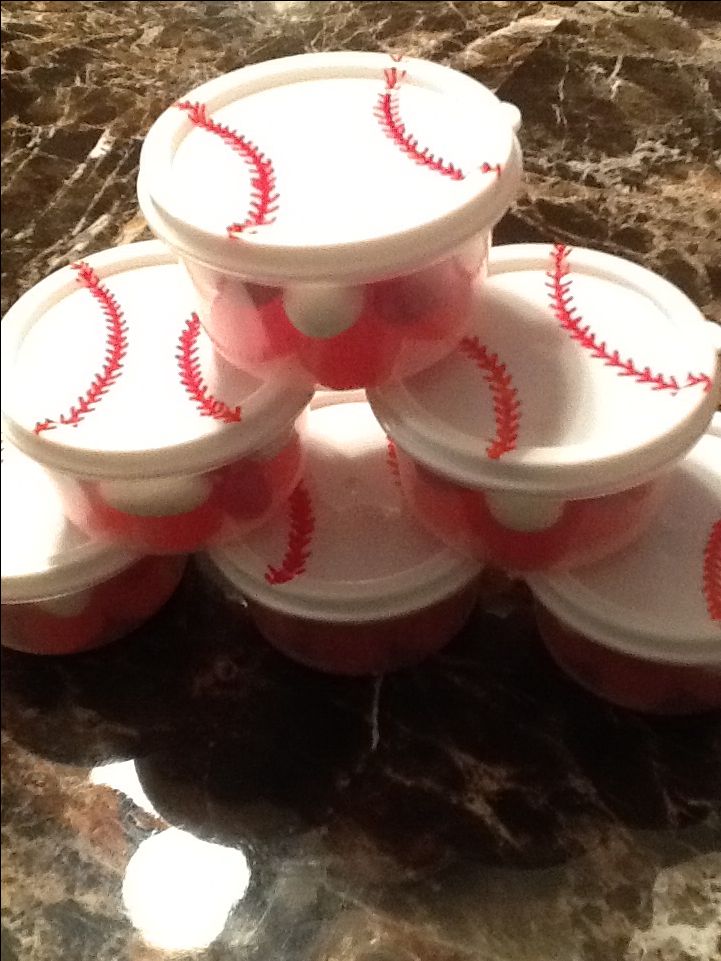 plastic cups with red baseballs on them sitting on a marble counter top, ready to be filled