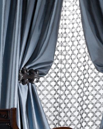 a chair sitting in front of a window covered in blue curtains