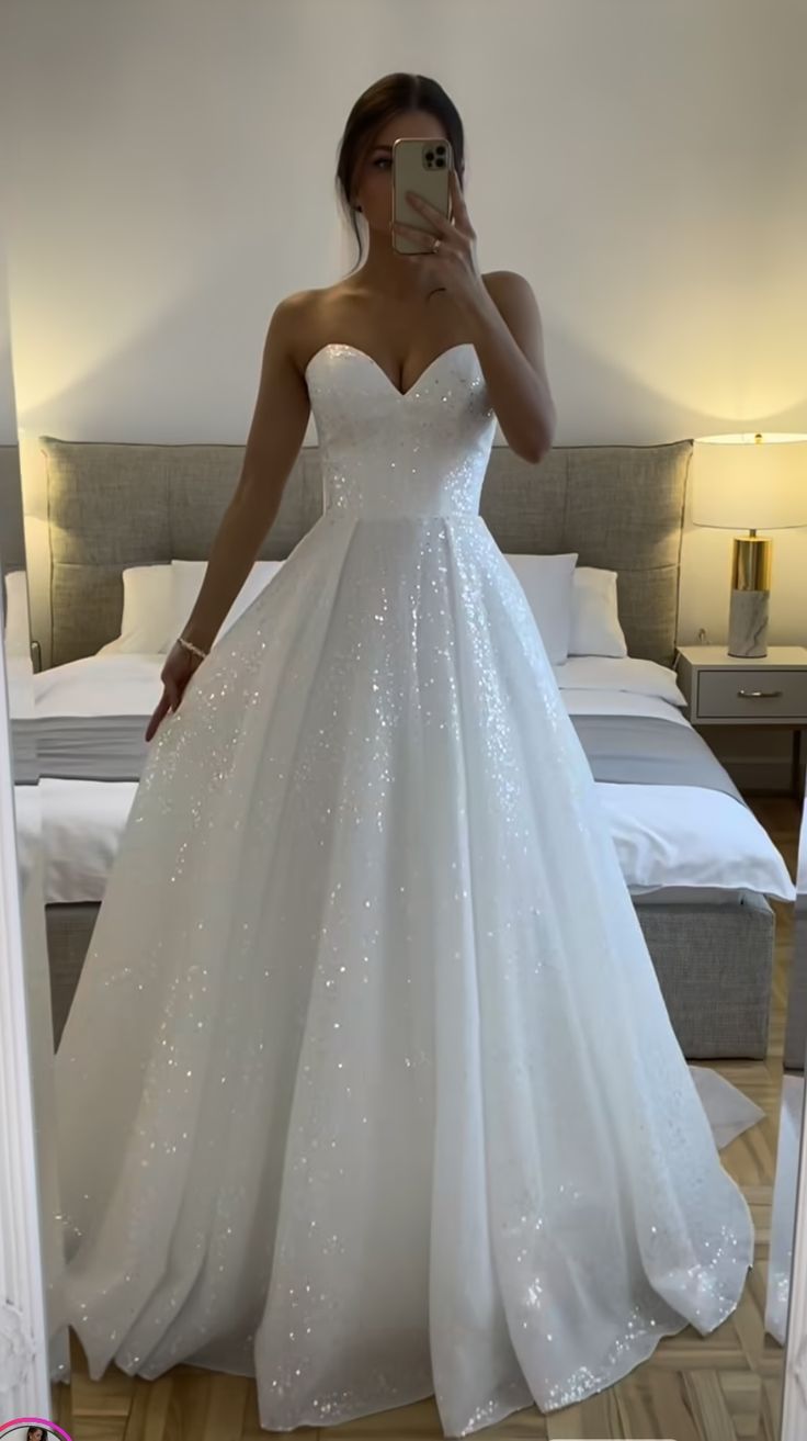 a woman is taking a selfie in her wedding dress while looking into the mirror