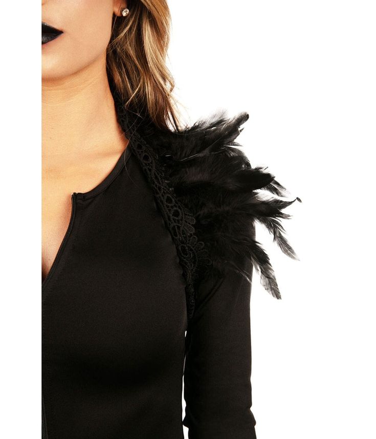 a woman wearing a black top with feathers on it