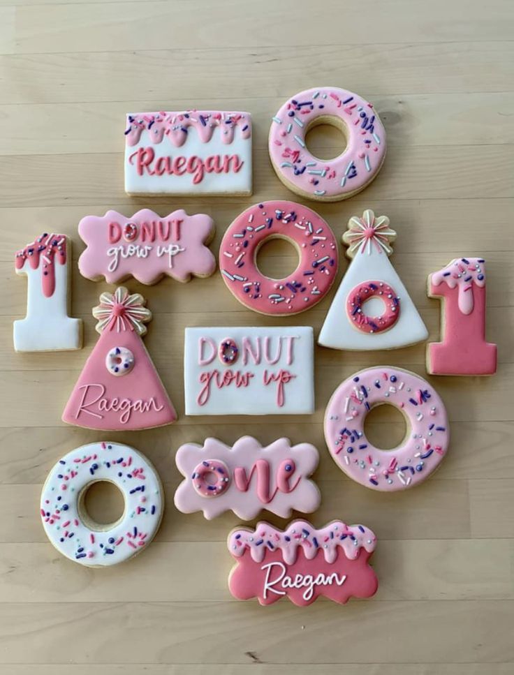 decorated donuts are arranged in the shape of letters and numbers on a wooden surface