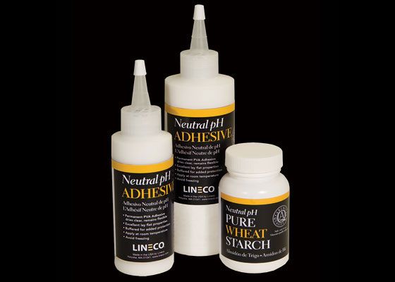 three bottles of adhesive on a black background