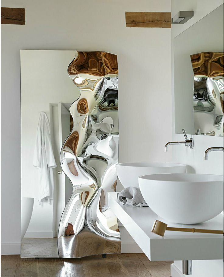 a bathroom with a sink, mirror and large white bowl on the counter in front of it