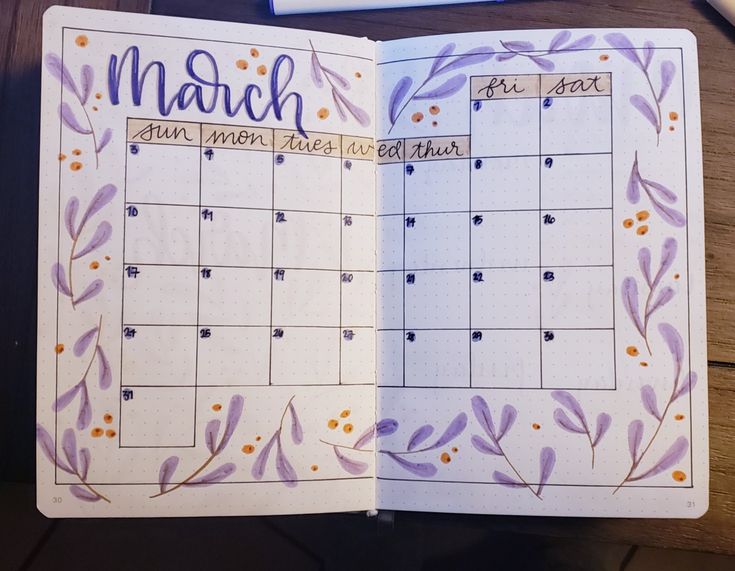 an open planner book with purple and orange flowers on the pages that are marked march