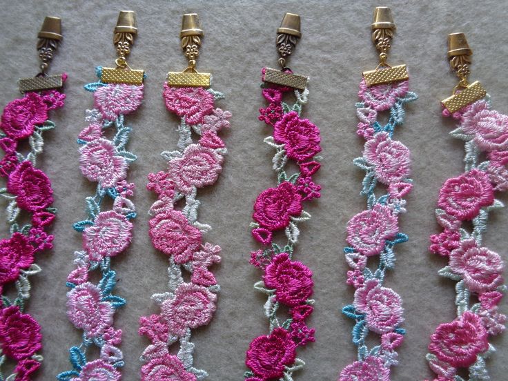 four crocheted bracelets with gold clasps and flowers on each side, all in different colors