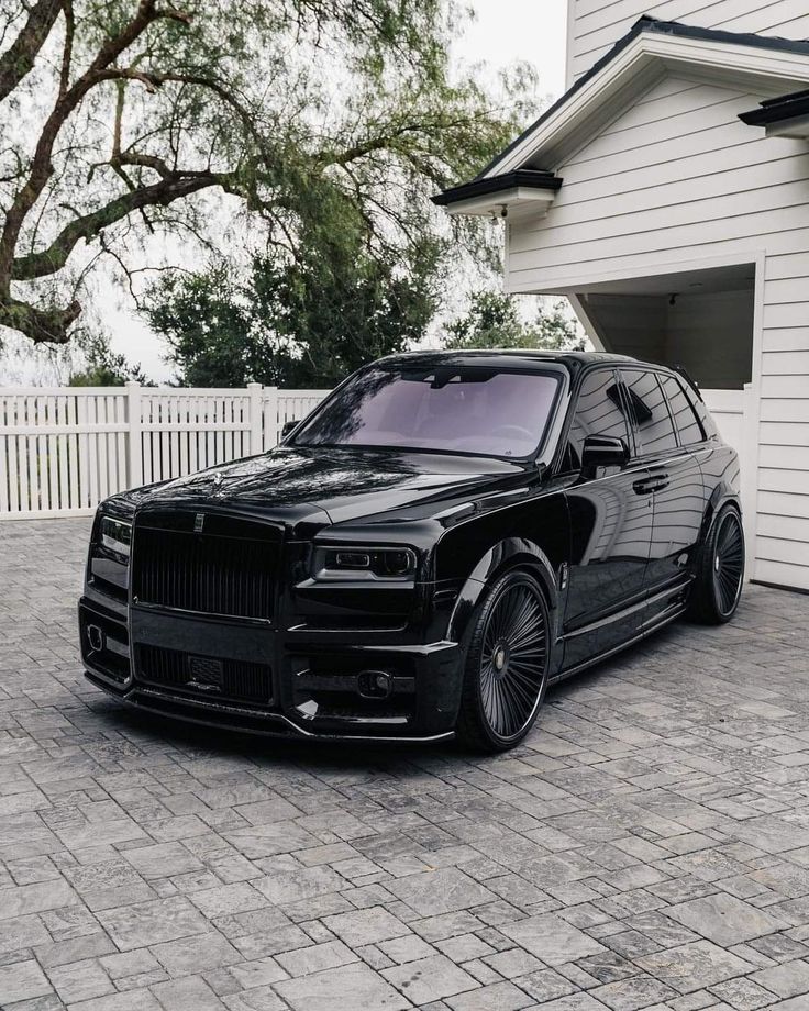 a black car parked in front of a white house