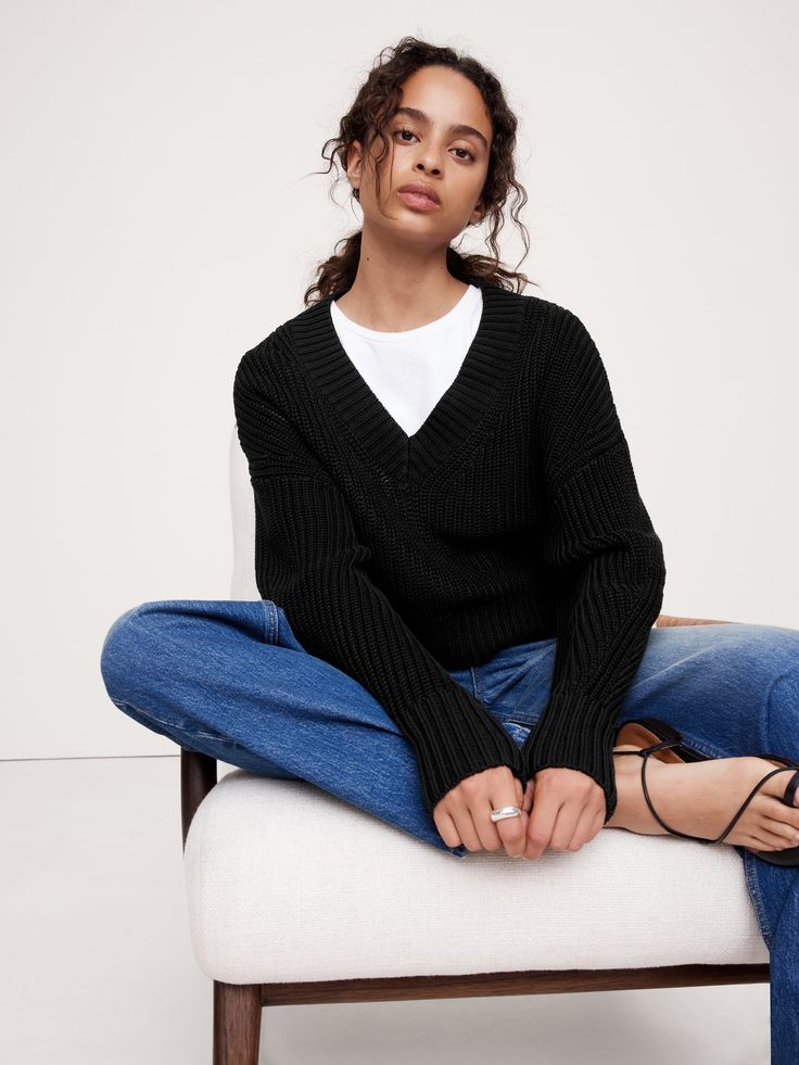 We cut this oversized sweater with a cropped hem, knitting it in our chunky, mercerized cotton yarn—a special process that produces a smoother, silkier handfeel with a signature luster.  Cut in a wedge shape, distinguished by its wide fit at the shoulders that gently tapers towards the hem.  Oversized fit.  Cropped length.  Organic: Made with certified, organically grown cotton that's easier on the earth.  V-neck.  Straight hem.  Oversized fit.  Long sleeves.  Cropped length.  Model: Size S, 5'1 Black V Neck Sweater Outfit, Black V Neck Sweater, Mercerized Cotton Yarn, Cotton Jumper, Chunky Knitwear, Set Outfit, Outerwear Sweater, Oversized Sweater, Newborn Outfits