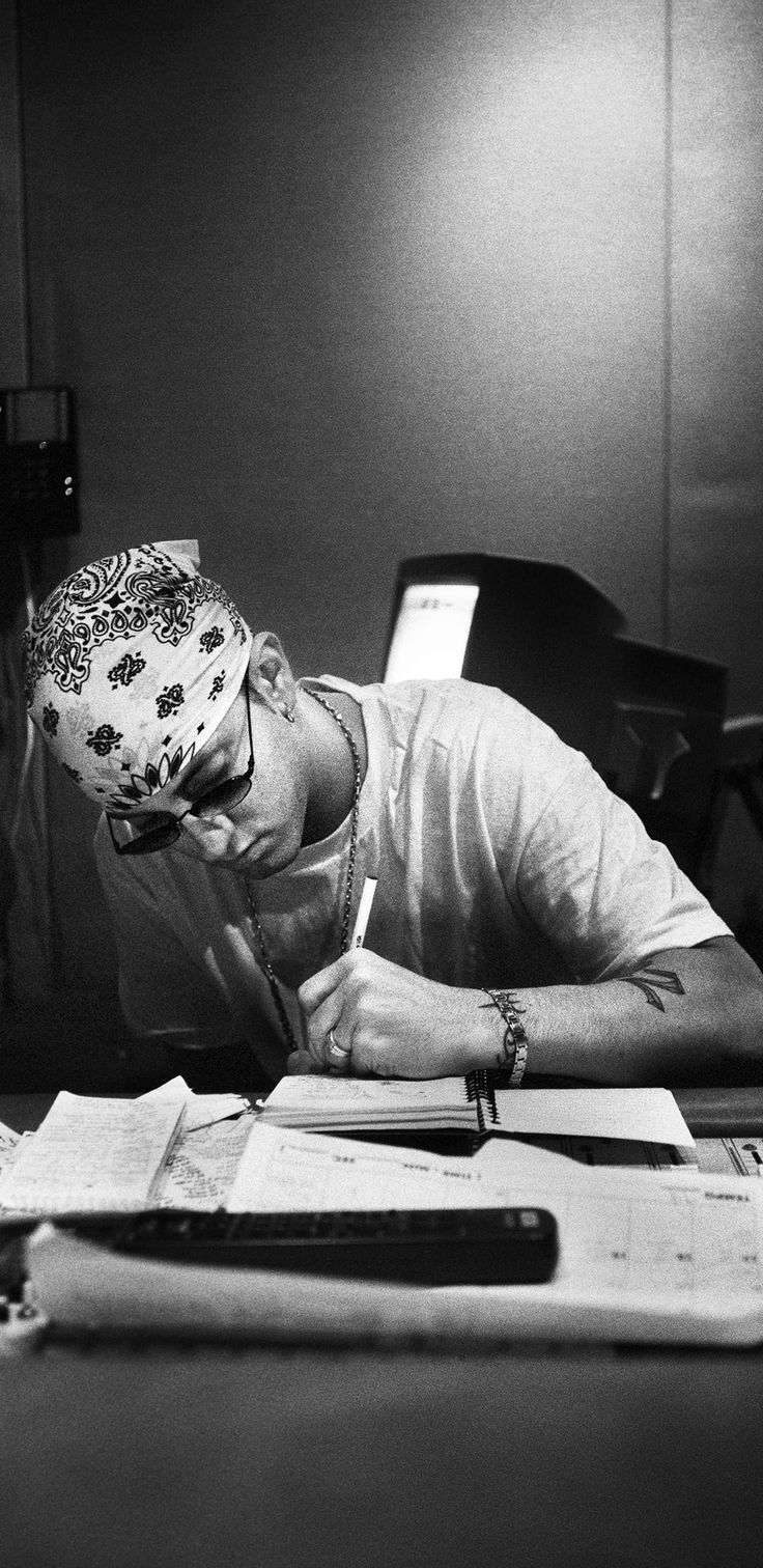 a man sitting at a desk writing on a piece of paper