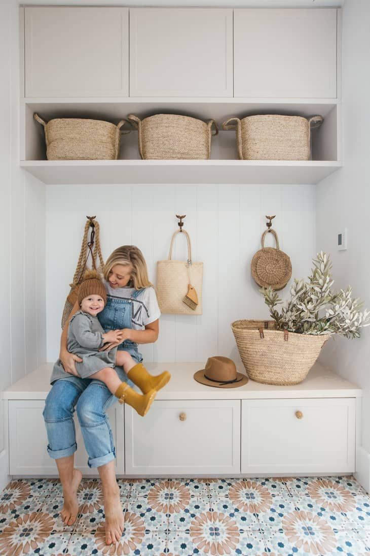 a woman holding a child in her arms while sitting on a bench next to baskets