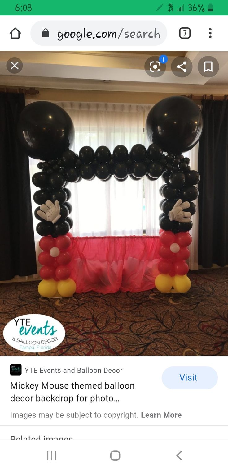 the mickey mouse balloon arch is decorated with black and red balloons, which are attached to each other