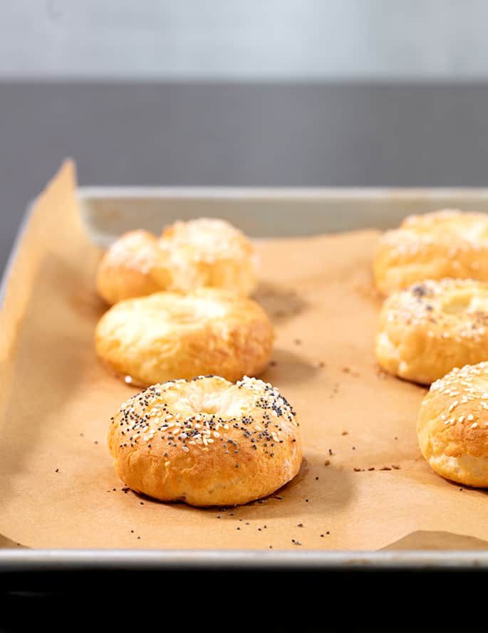 six bagels on a baking sheet ready to be baked