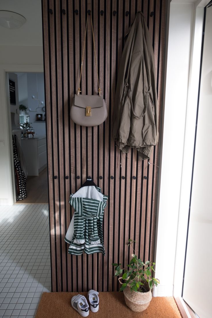 a coat rack with shoes and umbrellas on it next to a wall mounted coat rack