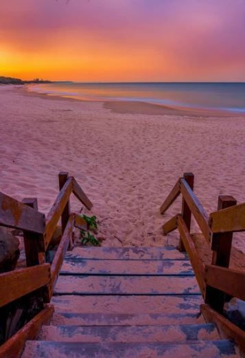 stairs lead down to the beach at sunset