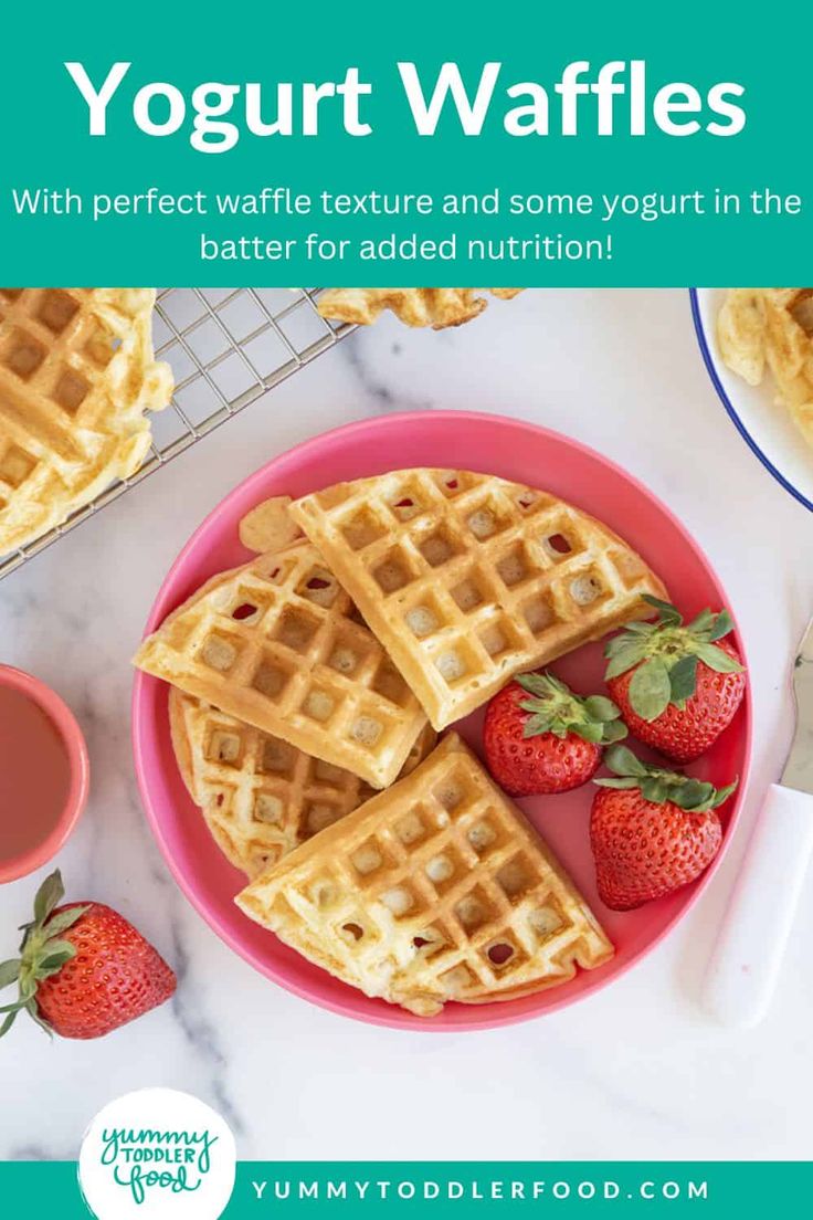 a pink plate topped with waffles and strawberries