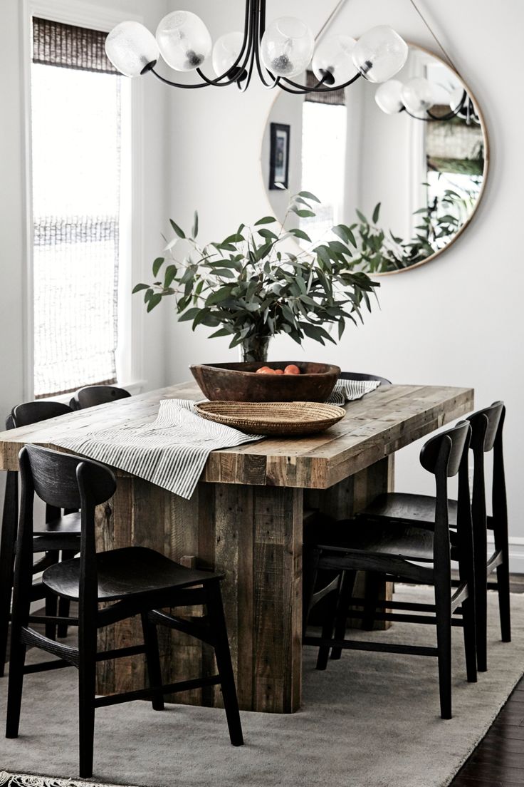 a dining room table with chairs and a potted plant on top of the table