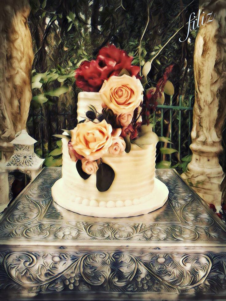 a three tiered cake with roses on top